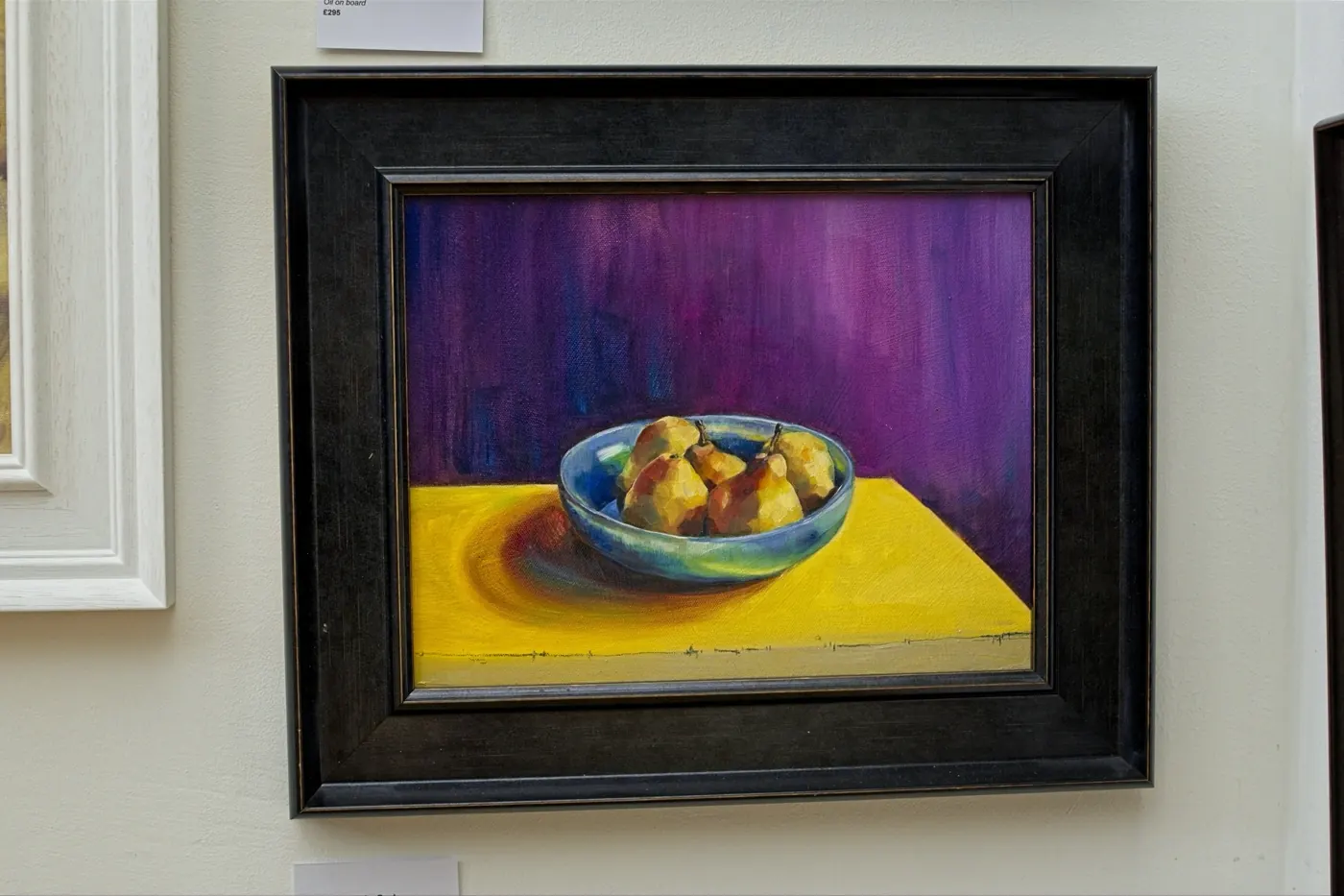 Pears in a turquoise bowl on a yellow table against violet